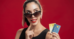 Mulher estilosa com óculos de sol segurando dois cartões de crédito, simbolizando escolhas inteligentes para maximizar milhas e recompensas em 2025.