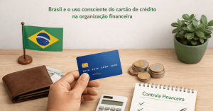imagem mostra uma mão segurando um cartão azul sobre uma mesa de madeira. Ao lado, há uma carteira com dinheiro, pilhas de moedas, uma calculadora e um bloco de anotações com o título “Controle Financeiro”. À esquerda, aparece uma pequena bandeira do Brasil e, à direita, um vaso com planta verde